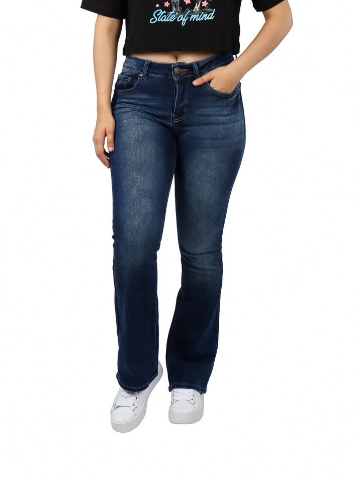 Mujer vistiendo pantalones jeans bootcut de color azul oscuro con efecto de lavado.