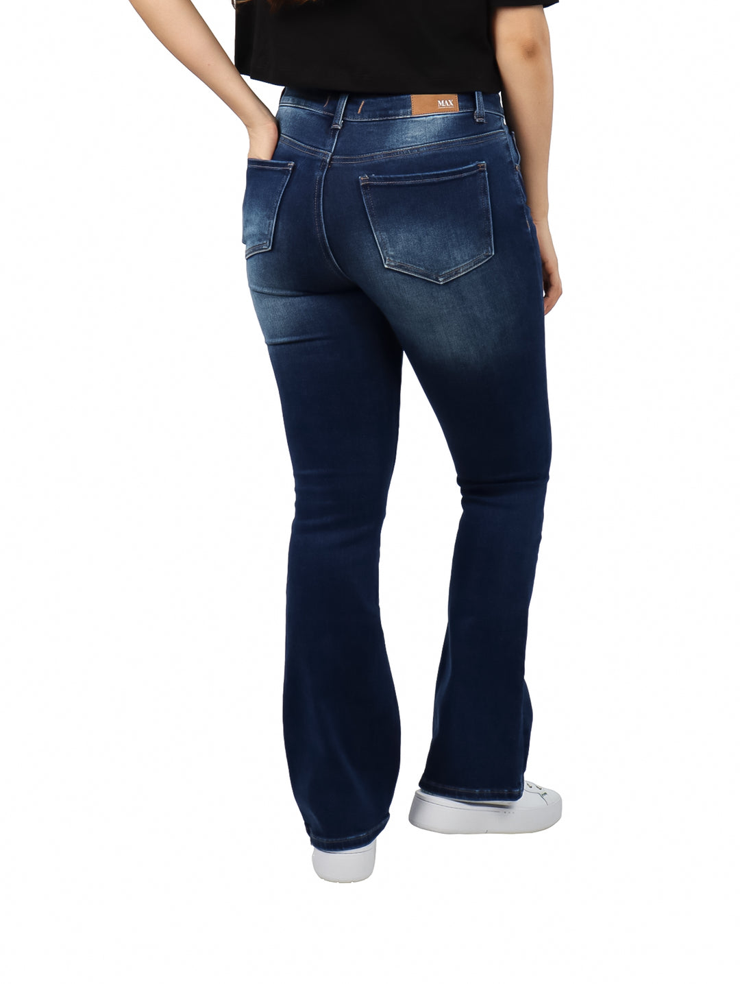 Mujer vistiendo pantalones jeans bootcut de color azul oscuro con efecto de lavado.