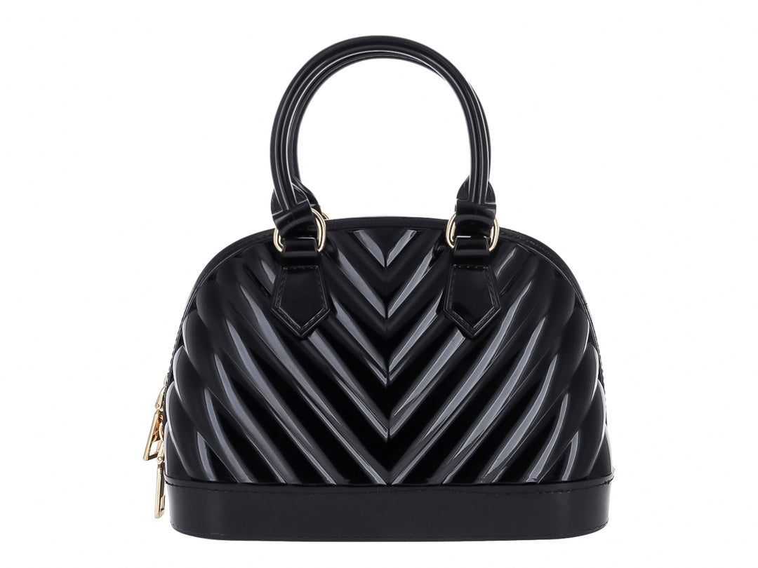 Bolsa de mano color negro brillante con diseño en relieve tipo chevron y detalles dorados.