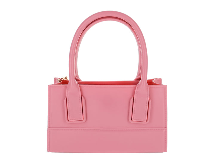 Bolso de mano color rosa pastel con diseño rectangular y asas cortas sobre fondo blanco.