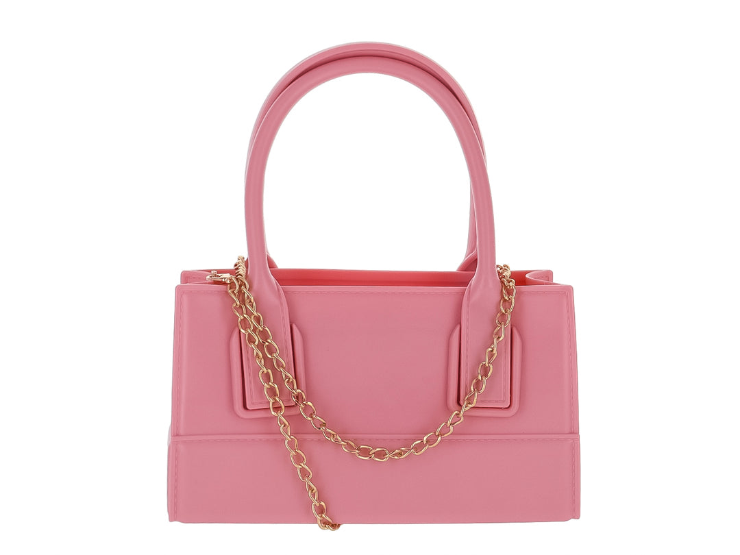 Bolso de mano color rosa pastel con diseño rectangular y asas cortas sobre fondo blanco.