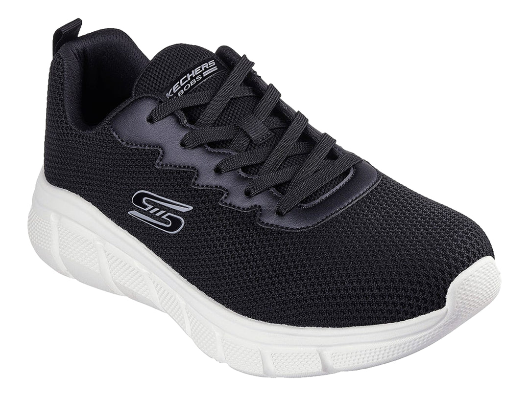 Tenis Skechers color negro con suela blanca y logotipo lateral en color gris.