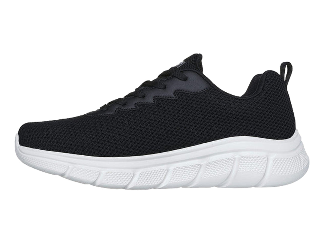 Tenis Skechers color negro con suela blanca y logotipo lateral en color gris.