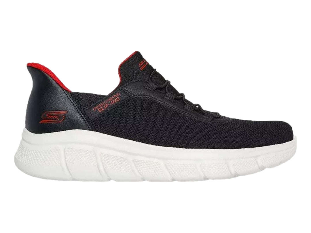 Tenis Skechers negros con suela blanca y detalles en rojo, diseño deportivo de malla.