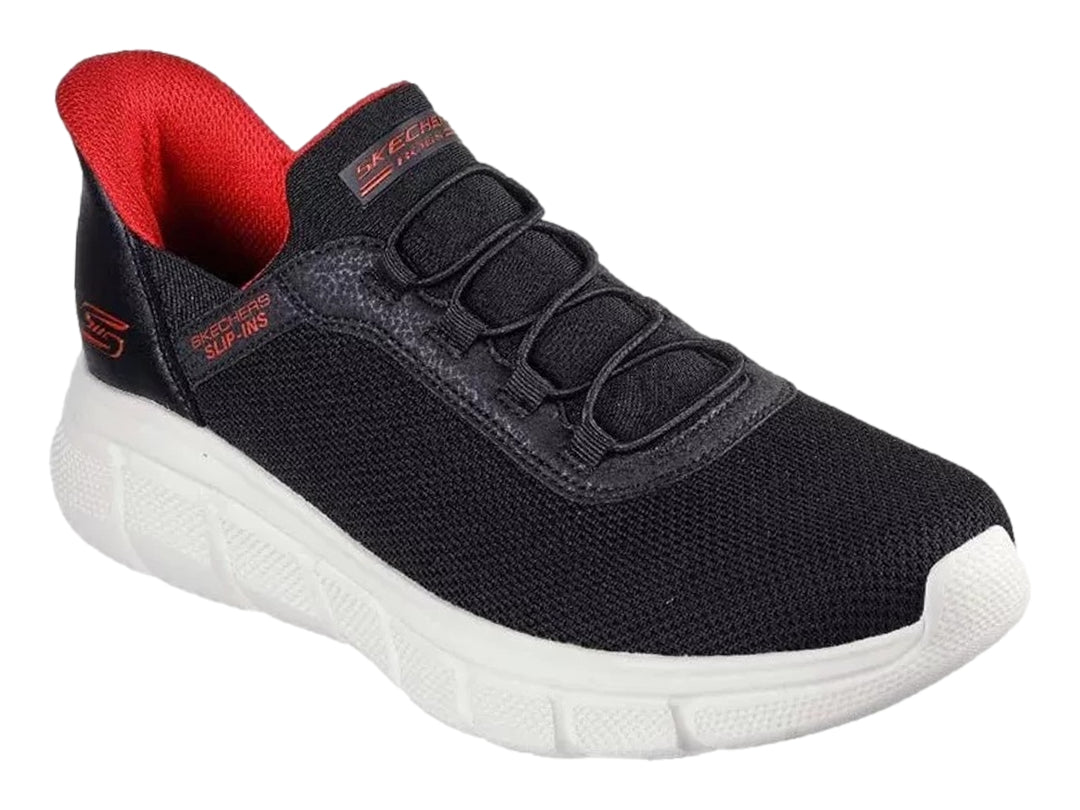 Tenis Skechers negros con suela blanca y detalles en rojo, diseño deportivo de malla.
