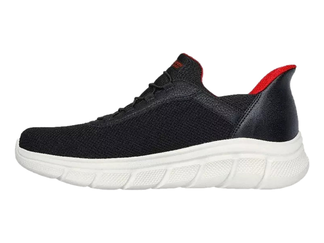 Tenis Skechers negros con suela blanca y detalles en rojo, diseño deportivo de malla.