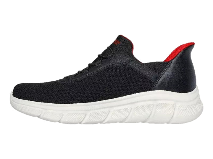 Tenis Skechers negros con suela blanca y detalles en rojo, diseño deportivo de malla.