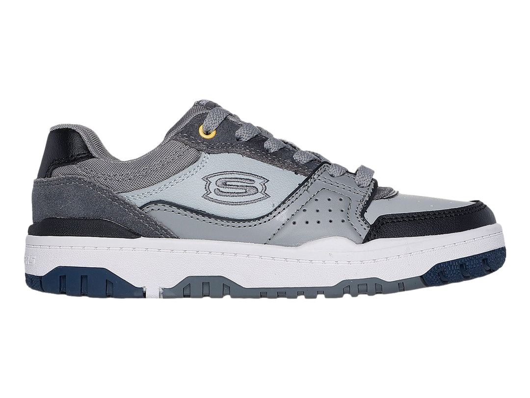 Tenis Skechers color gris y negro con suela blanca y detalles en azul marino.