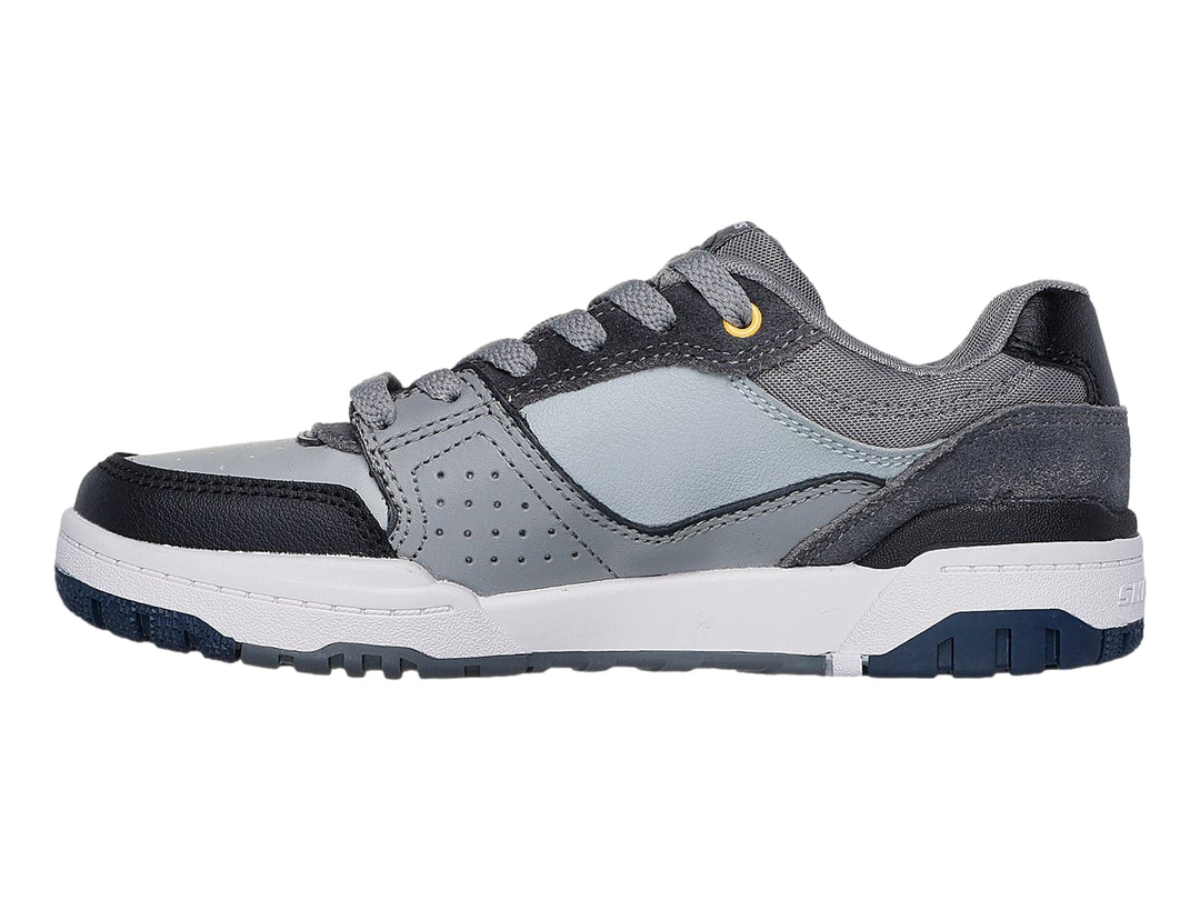 Tenis Skechers color gris y negro con suela blanca y detalles en azul marino.