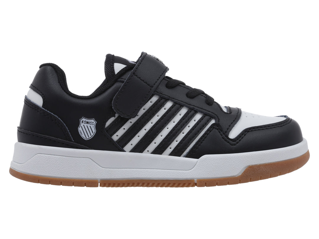 Tenis infantiles K-Swiss en color negro y blanco con suela de goma marrón y cierre de velcro.