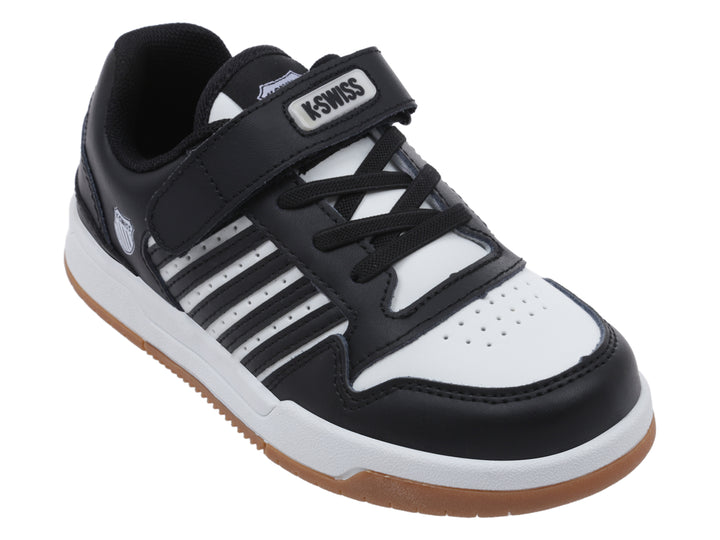 Tenis infantiles K-Swiss en color negro y blanco con suela de goma marrón y cierre de velcro.