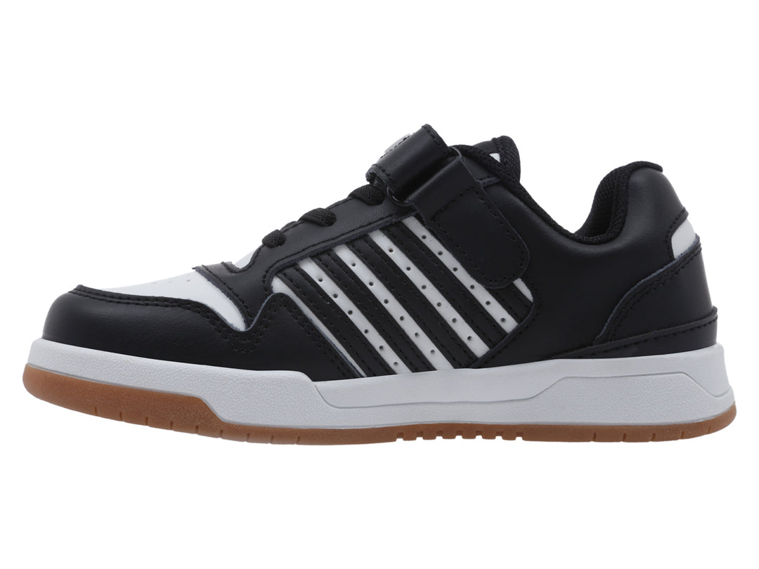 Tenis infantiles K-Swiss en color negro y blanco con suela de goma marrón y cierre de velcro.