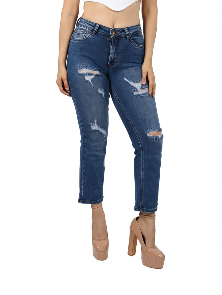 Jeans azul oscuro para mujer con efecto desgastado y roturas en las piernas.