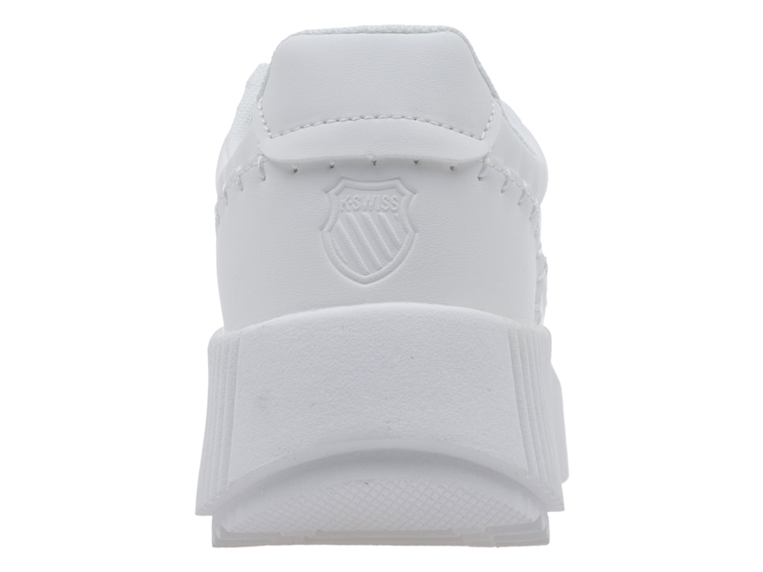 Tenis blancos K-Swiss con suela de plataforma acanalada y logo dorado lateral.