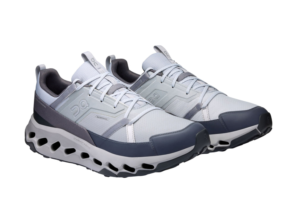 Tenis deportivos On Cloud en colores blanco, gris y azul marino con suela tecnológica perforada.