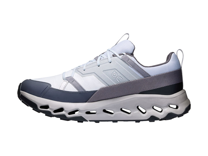 Tenis deportivos On Cloud en colores blanco, gris y azul marino con suela tecnológica perforada.