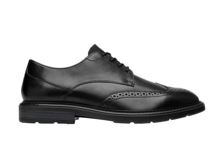 Zapato formal negro de cuero con detalles perforados y cordones.