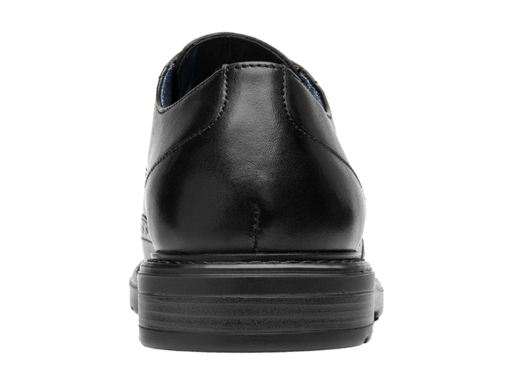 Zapato formal negro de cuero con detalles perforados y cordones.