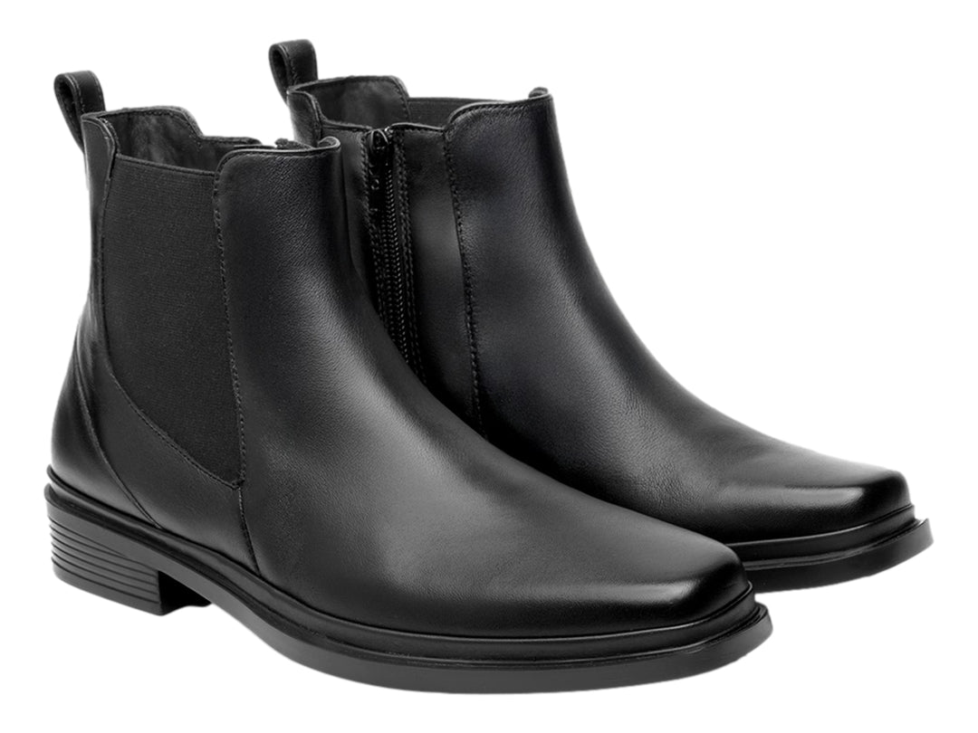 Botín estilo Chelsea de cuero negro con paneles elásticos laterales y suela negra.
