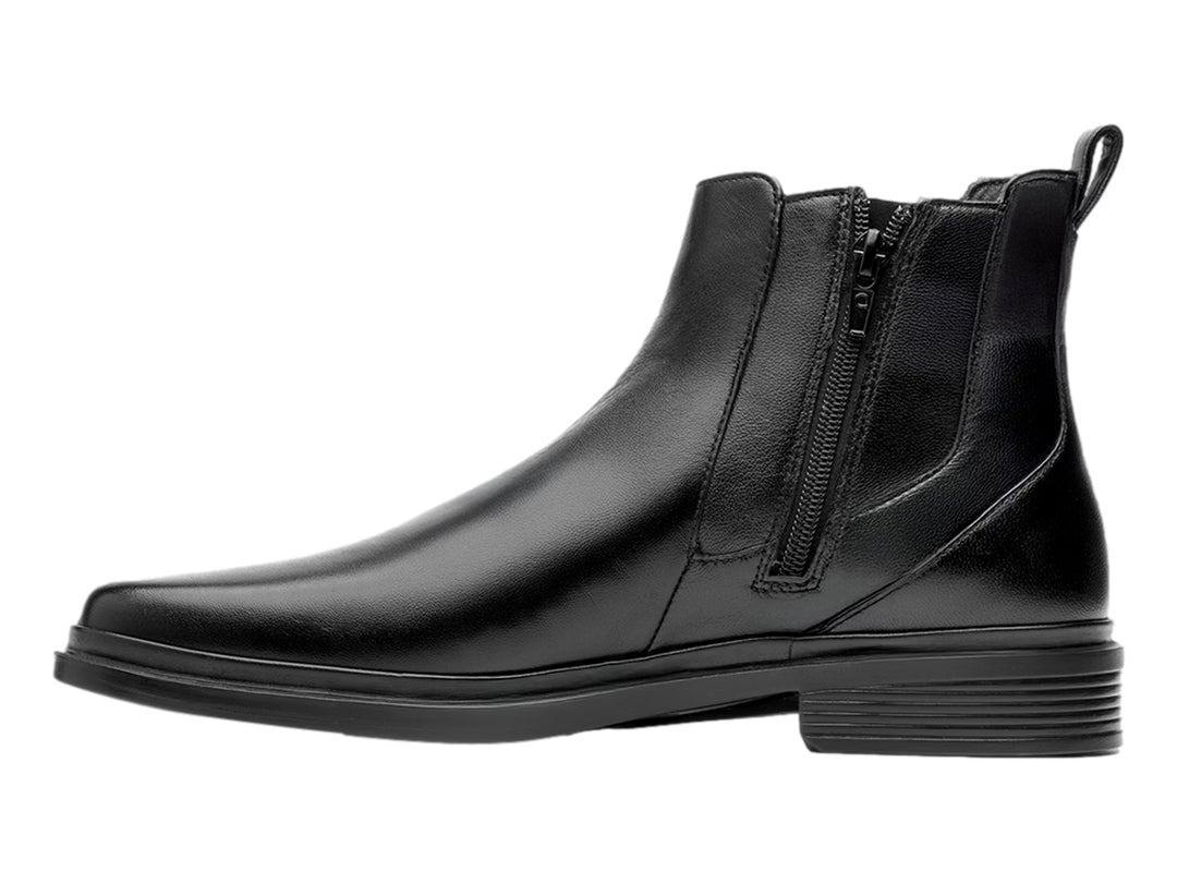 Botín estilo Chelsea de cuero negro con paneles elásticos laterales y suela negra.