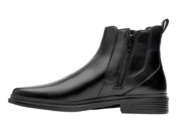Botín estilo Chelsea de cuero negro con paneles elásticos laterales y suela negra.