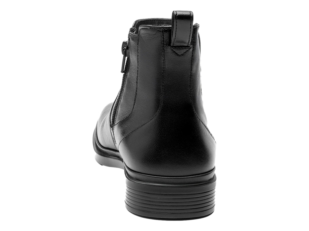 Botín estilo Chelsea de cuero negro con paneles elásticos laterales y suela negra.