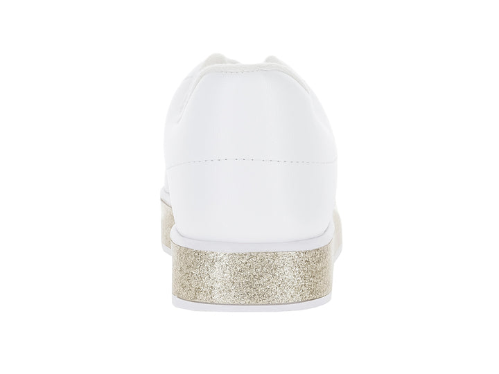 Tenis blancos para niña con suela gruesa en color dorado brillante y agujetas blancas.