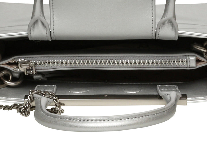Bolso de hombro Steve Madden modelo Bvinka en color plata brillante con asa corta y correa larga ajustable.