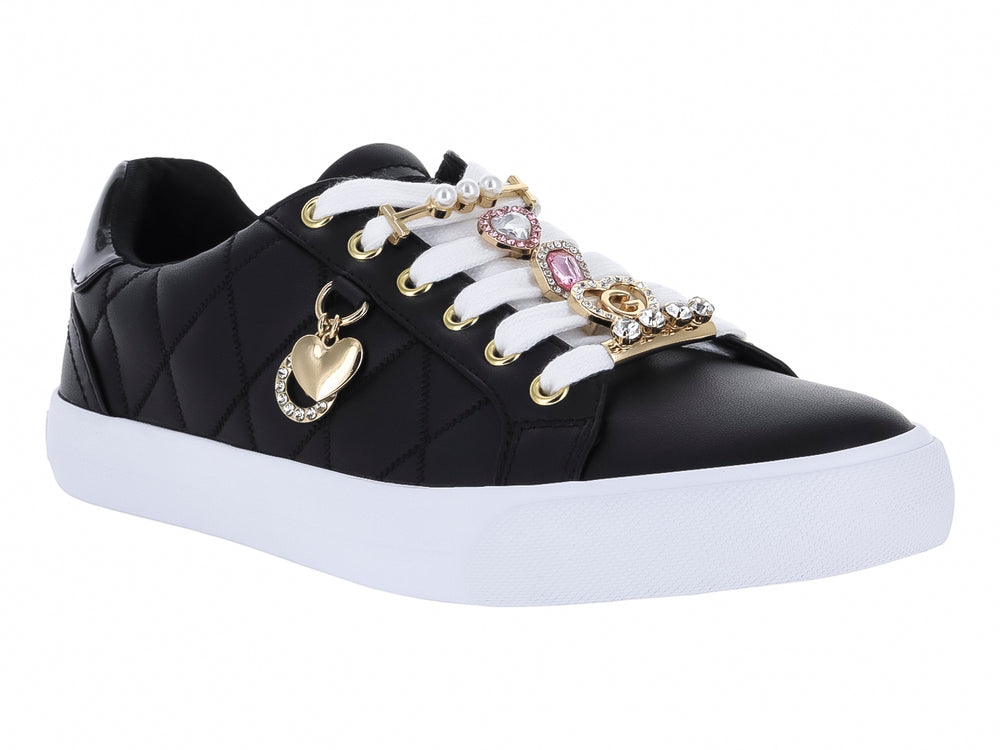 Tenis negros para mujer con diseño acolchado, suela blanca y adornos de corazones dorados.