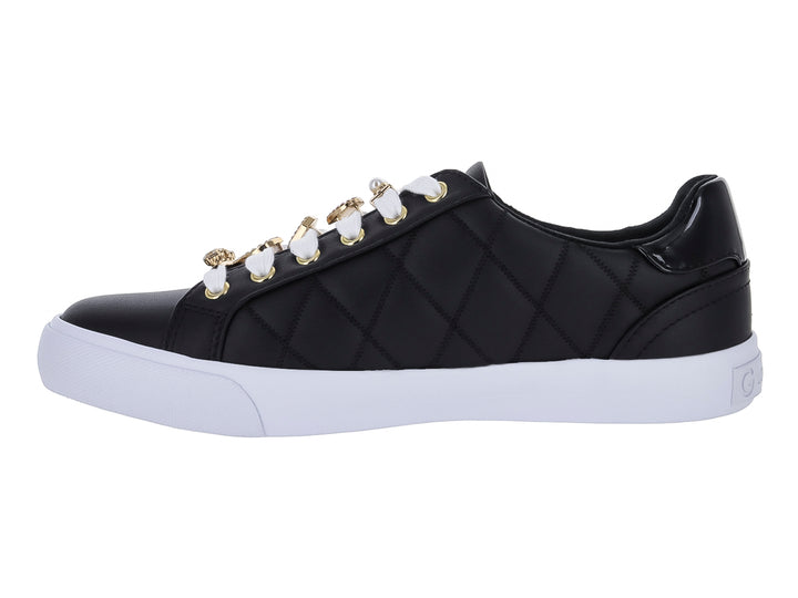 Tenis negros para mujer con diseño acolchado, suela blanca y adornos de corazones dorados.