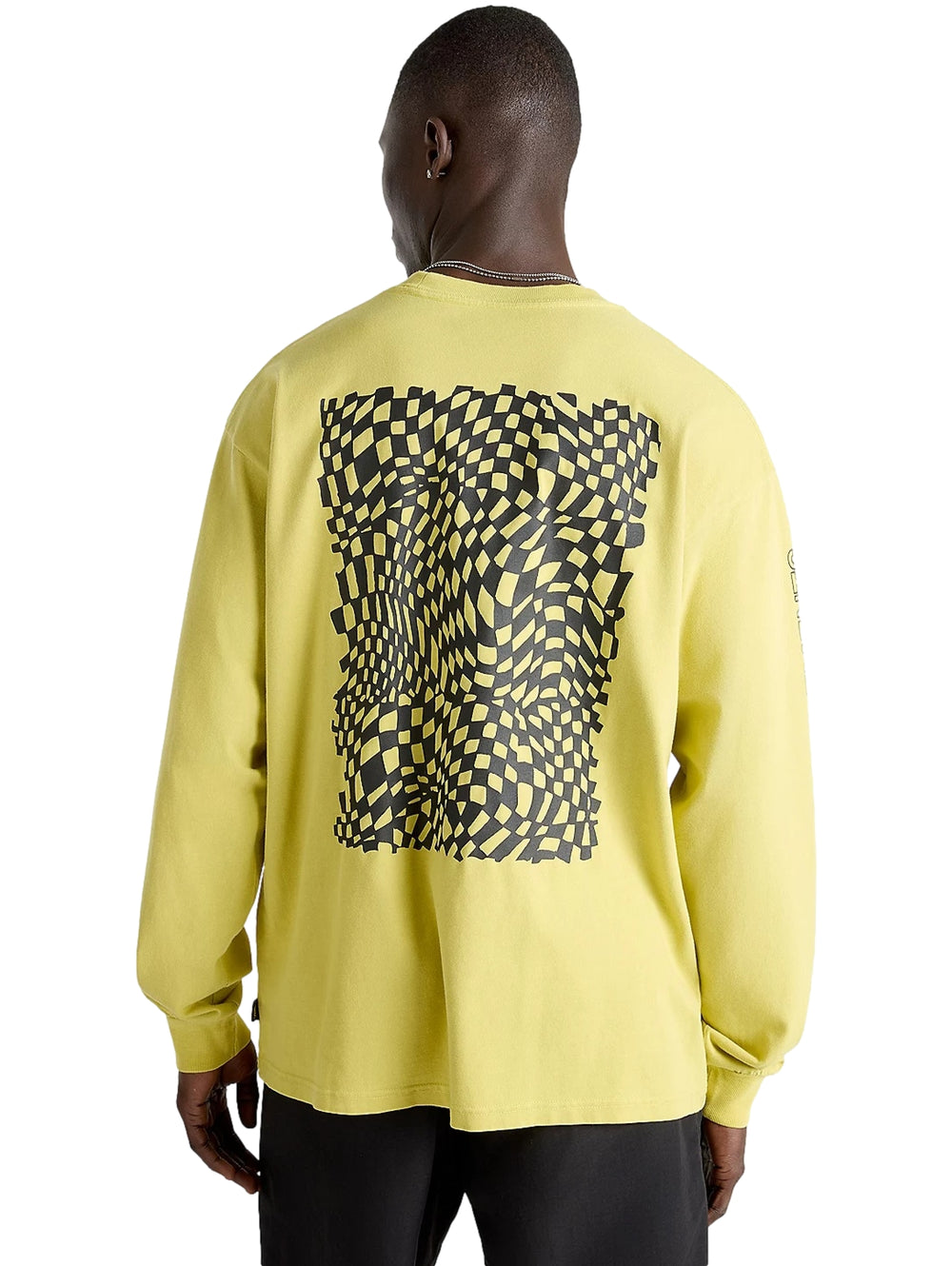 Hombre vistiendo camiseta de manga larga color oliva con logotipos de VANS en negro.