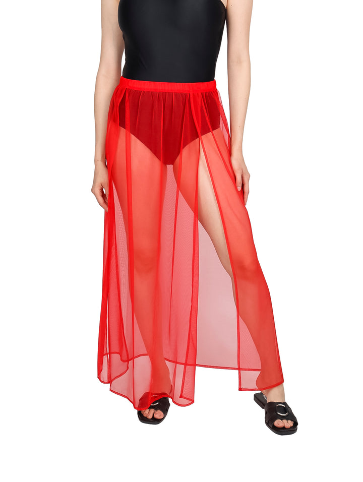 Falda larga de malla color rojo para playa sobre traje de baño negro.