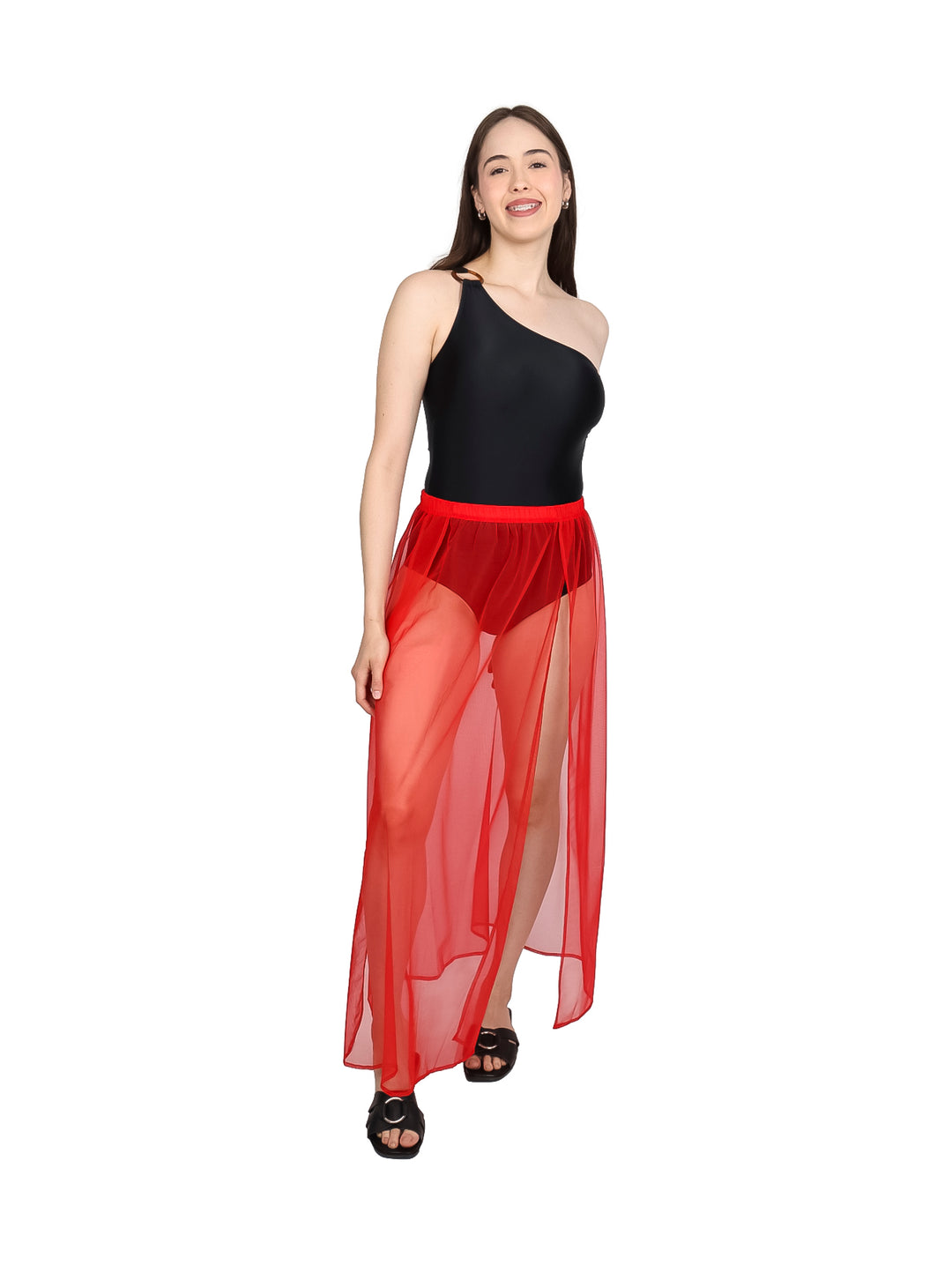 Falda larga de malla color rojo para playa sobre traje de baño negro.