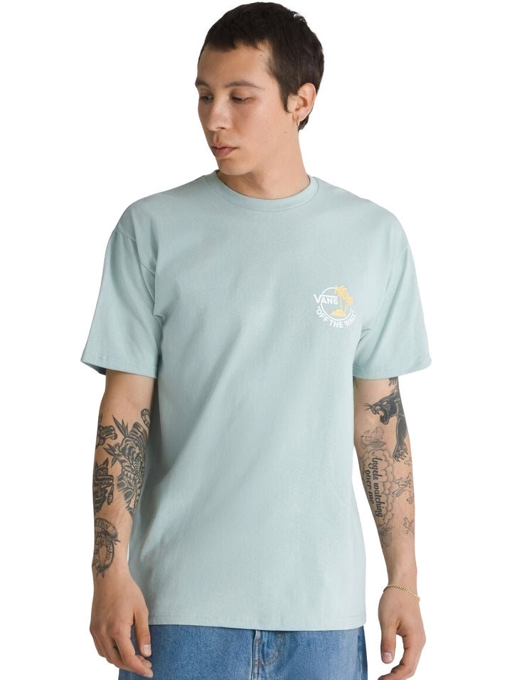 Hombre vistiendo playera Vans de color gris claro con un pequeño logotipo en el pecho.