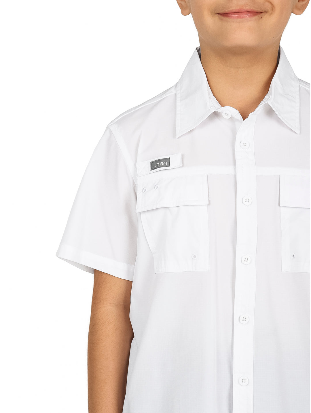 Niño con camisa blanca de manga corta y pantalones negros sobre fondo blanco.