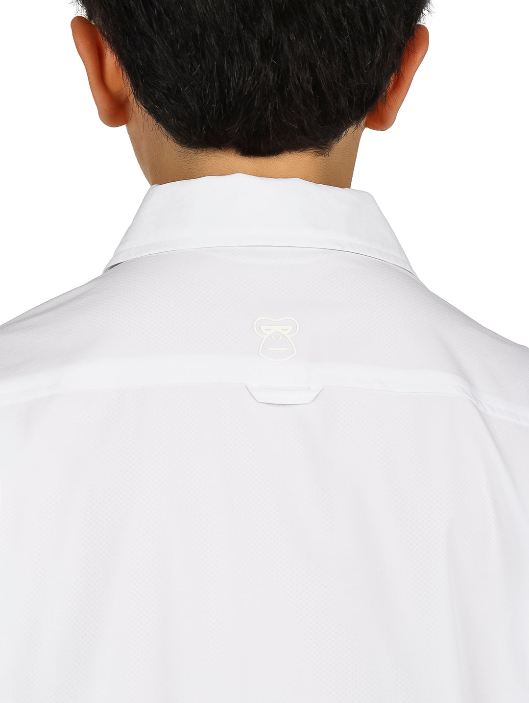 Ni�o con camisa blanca de manga corta y pantalones negros sobre fondo blanco.
