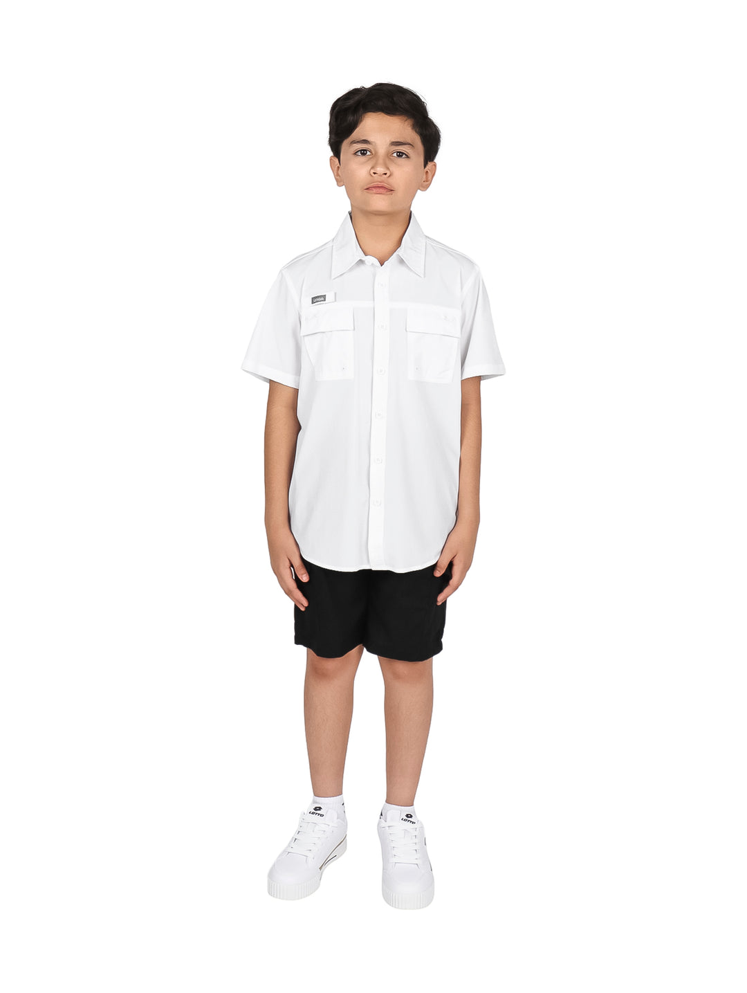 Niño con camisa blanca de manga corta y pantalones negros sobre fondo blanco.