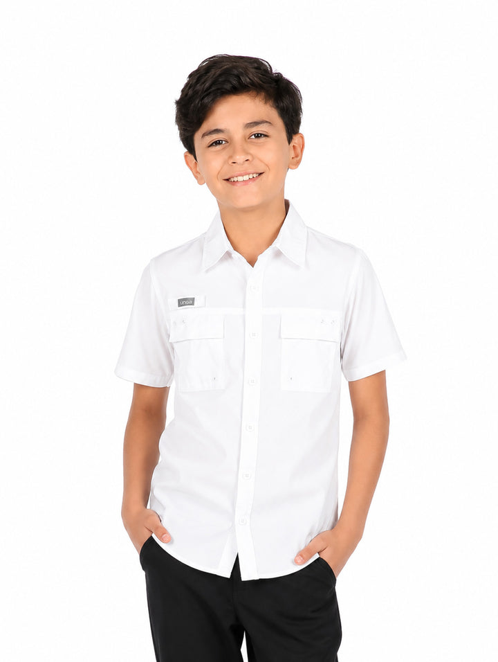 Niño vistiendo una camisa outdoor de color blanco con manga corta y dos bolsillos frontales.