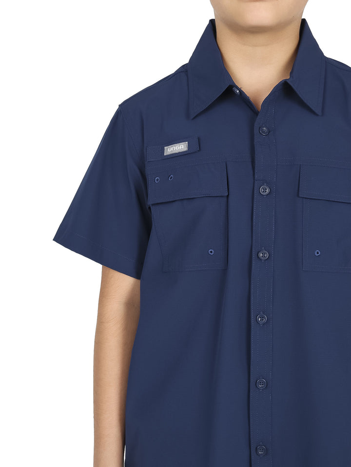 Niño vistiendo camisa outdoor de manga corta color azul navy con bolsillos frontales y cuello.