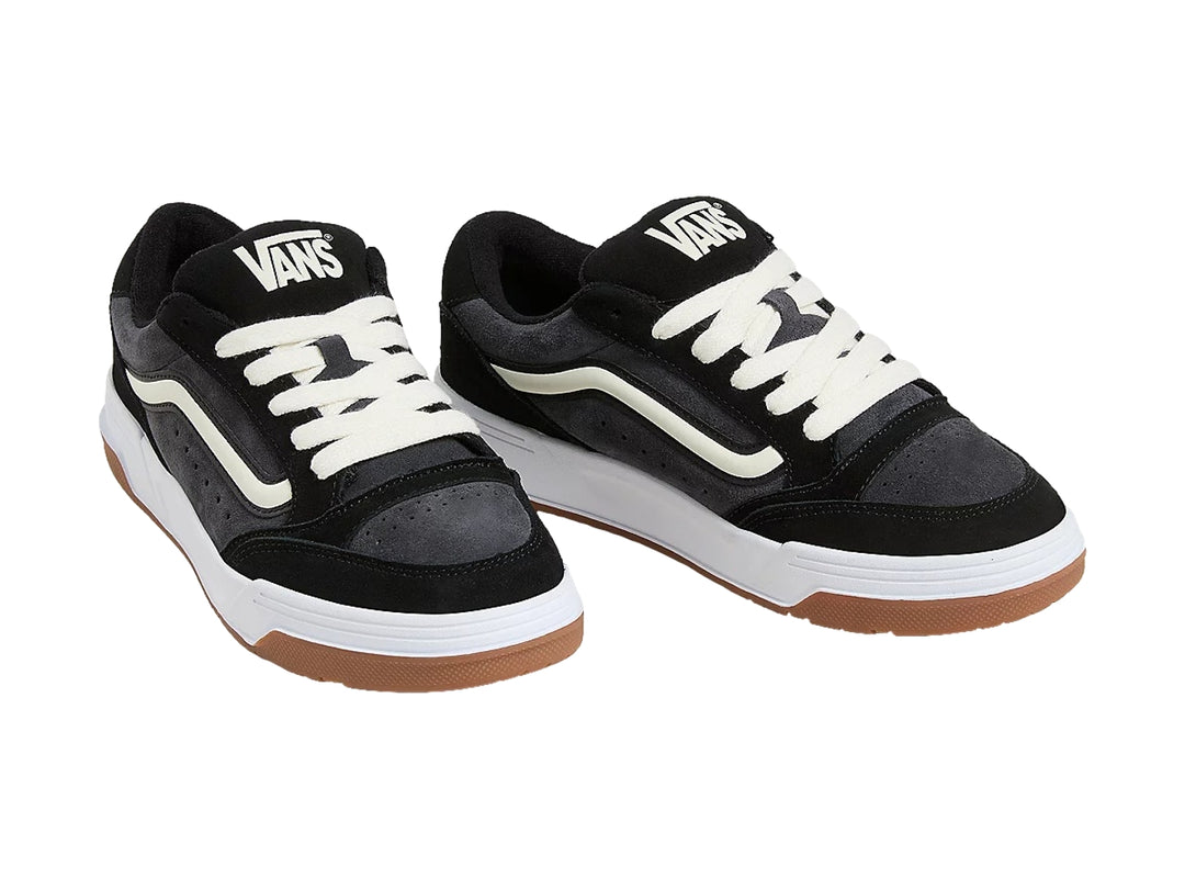 Tenis VANS color negro con suela blanca y café, detalles en blanco y agujetas blancas.
