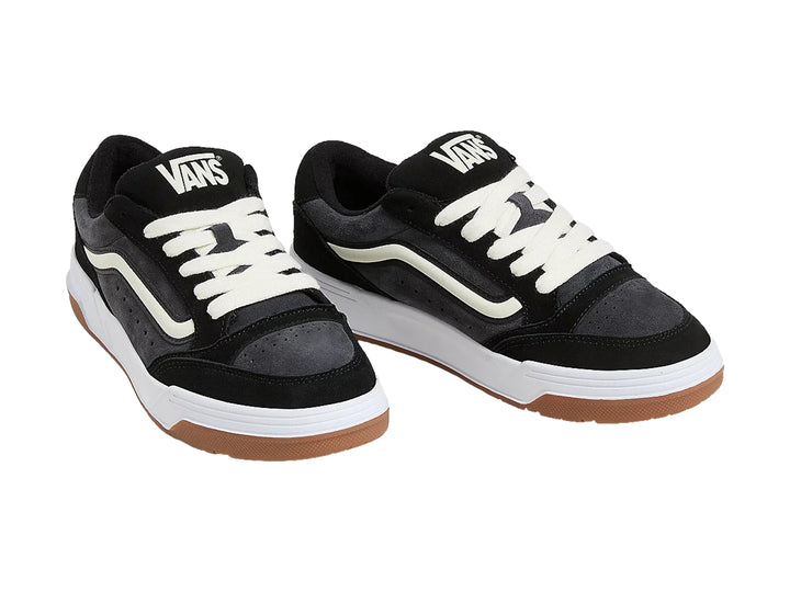 Tenis VANS color negro con suela blanca y café, detalles en blanco y agujetas blancas.