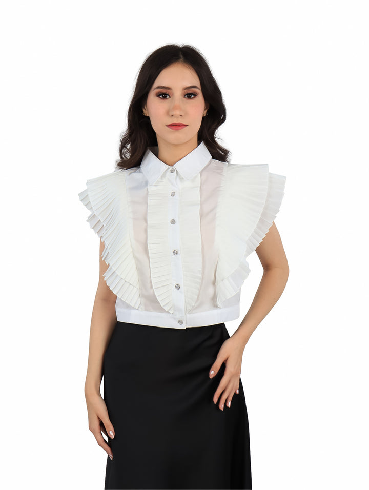 Blusa blanca de popelina sin mangas con cuello y detalles de volantes frontales y laterales.