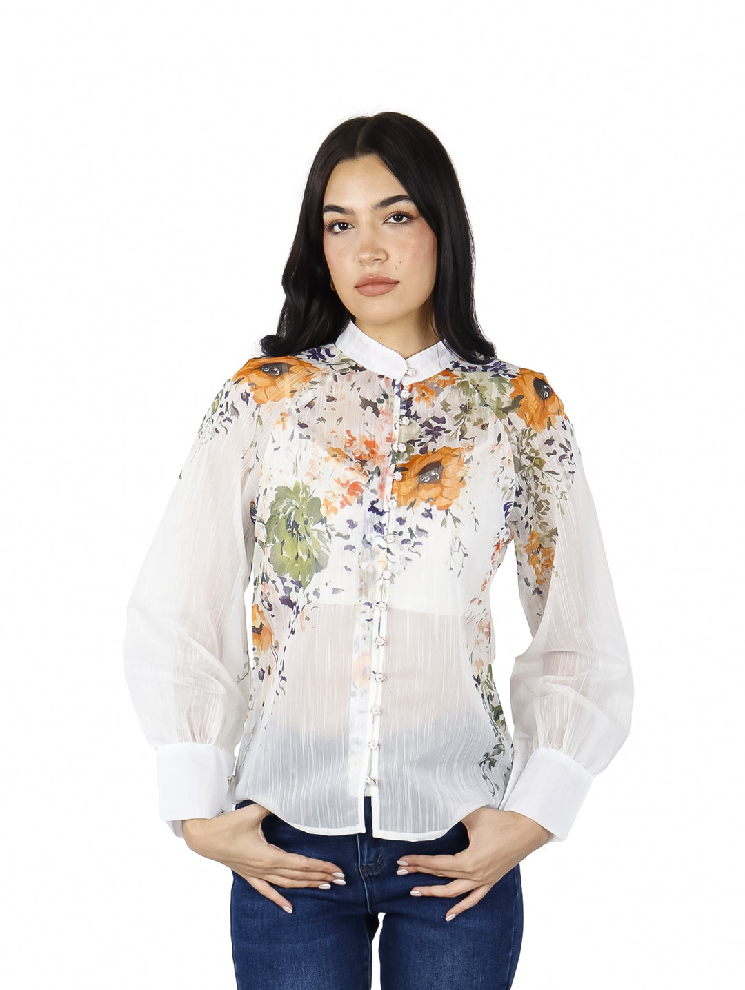 Blusa blanca de manga larga con estampado floral en tonos naranja y verde, con cuello y botones frontales.