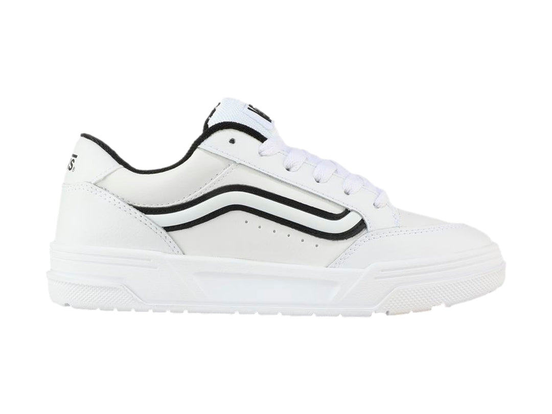 Tenis Vans blancos para Niño con franja lateral negra y suela blanca.