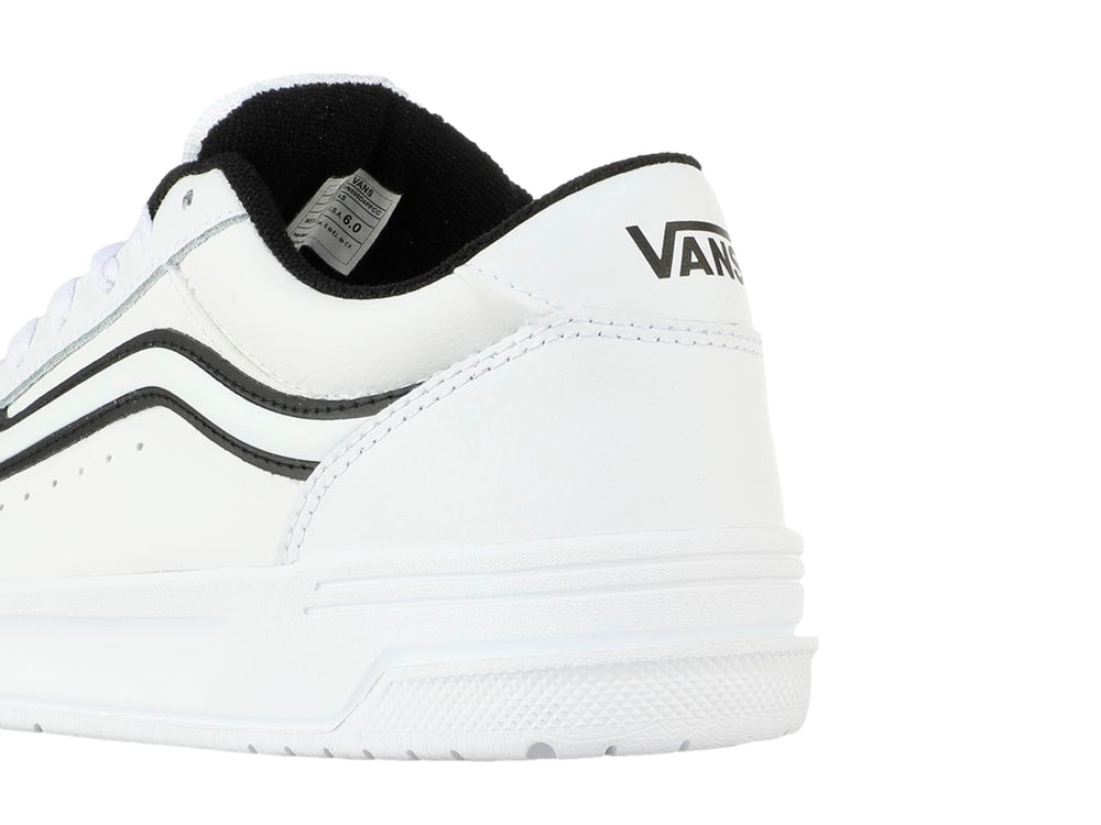 Tenis Vans blancos para Niño con franja lateral negra y suela blanca.