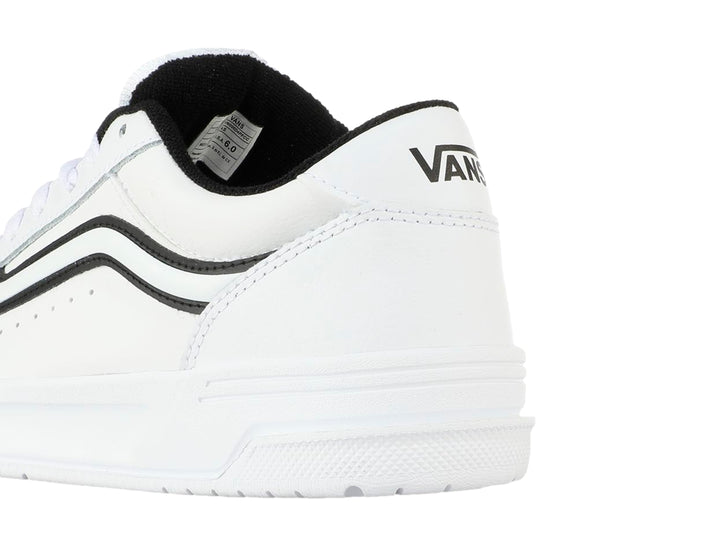 Tenis Vans blancos para Niño con franja lateral negra y suela blanca.