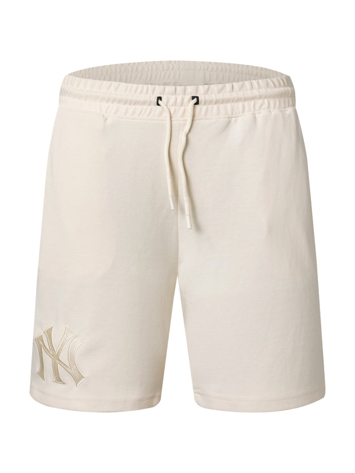Pantalones cortos deportivos color beige con logo de los New York Yankees en la pierna izquierda.