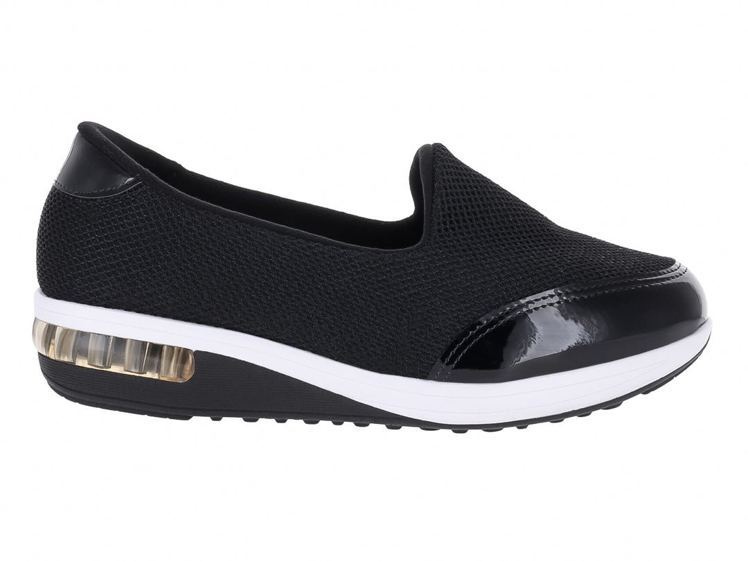 Zapato plano Modare negro de tela con detalles en charol y suela blanca con amortiguador transparente.