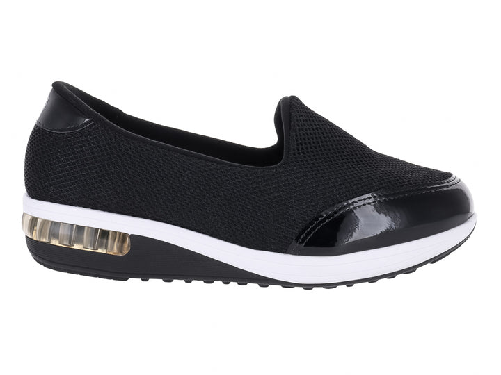 Zapato plano Modare negro de tela con detalles en charol y suela blanca con amortiguador transparente.