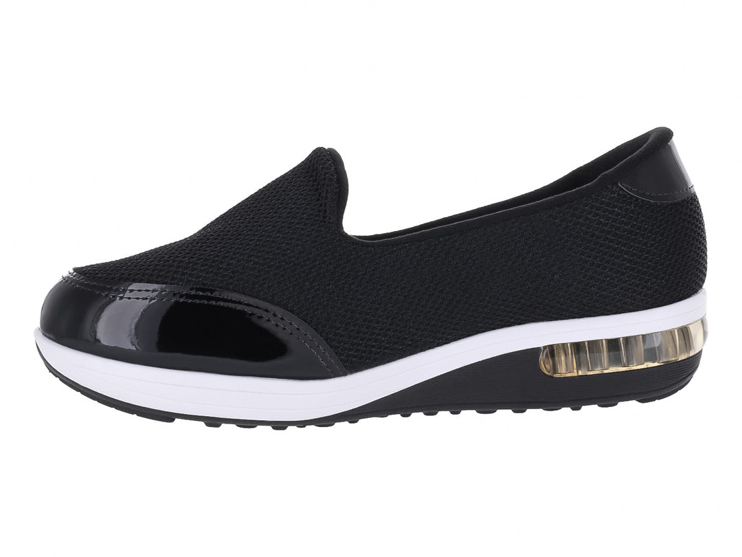 Zapato plano Modare negro de tela con detalles en charol y suela blanca con amortiguador transparente.